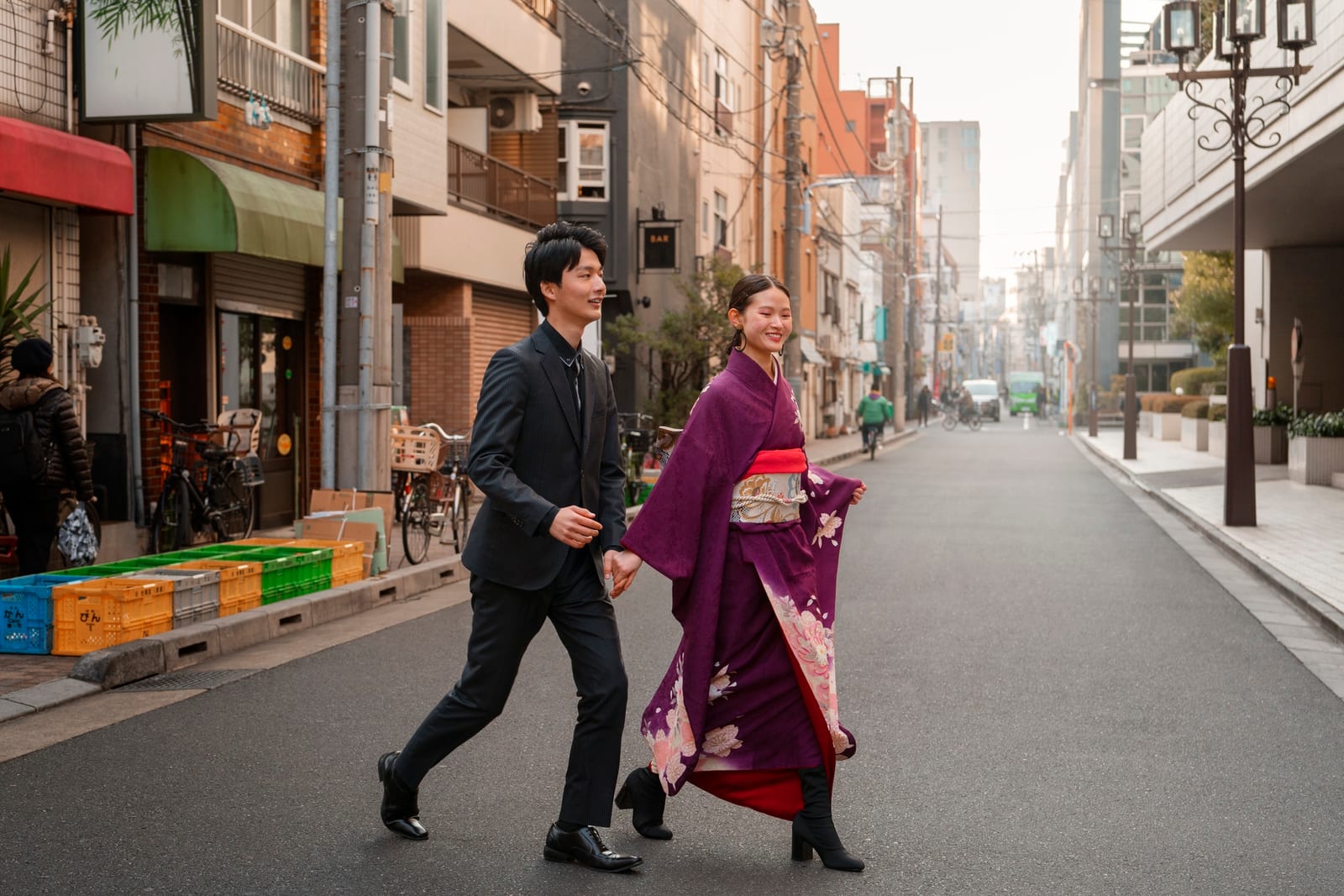 着物とスーツ姿の日本人カップルが街を歩いている様子