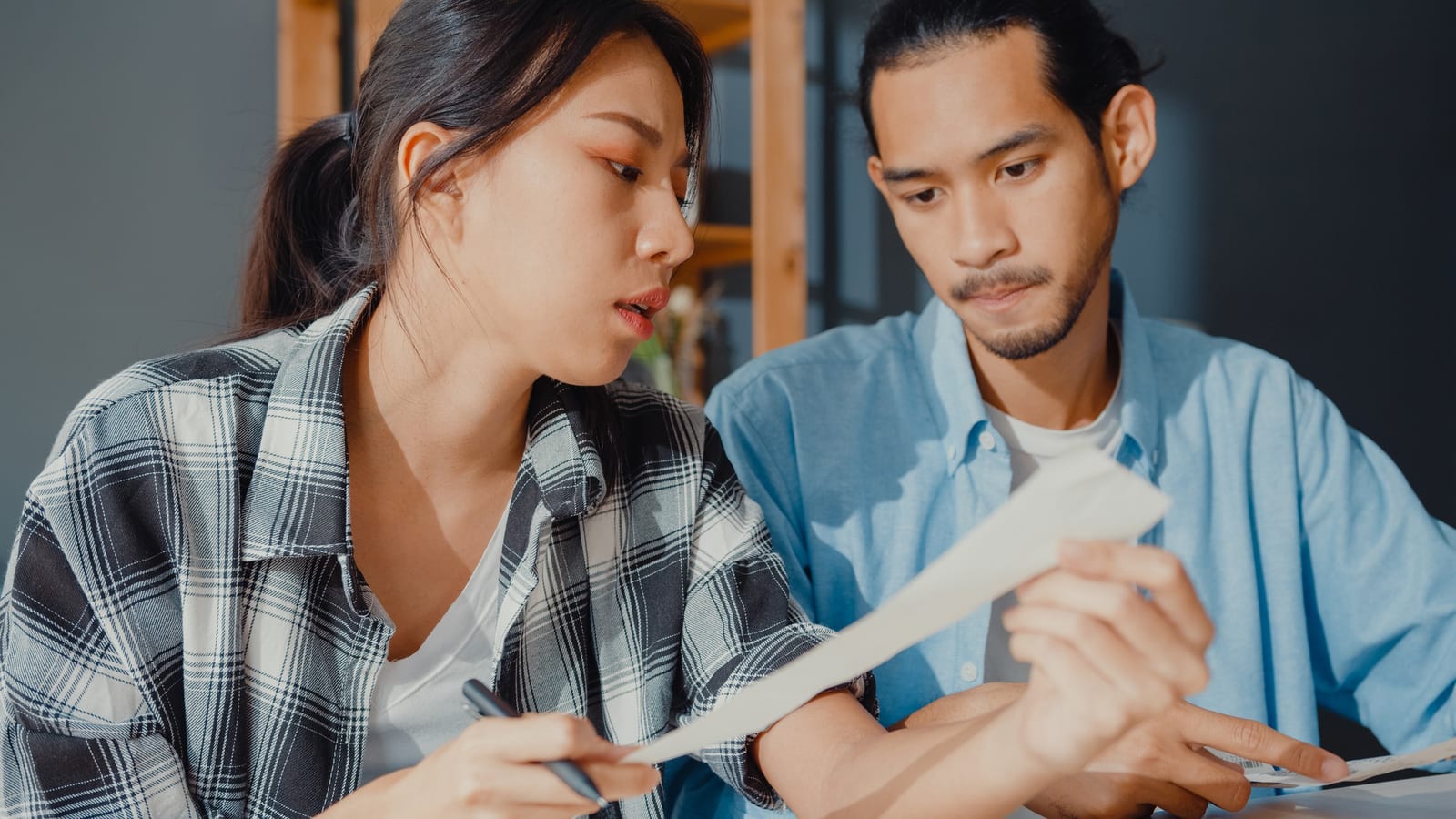 夫婦がテーブルで書類を確認し合っている様子